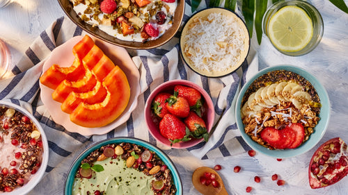 Amazin’ Graze breakfast bowls with fruit, granola, oats, papaya, strawberries, and lemon water.