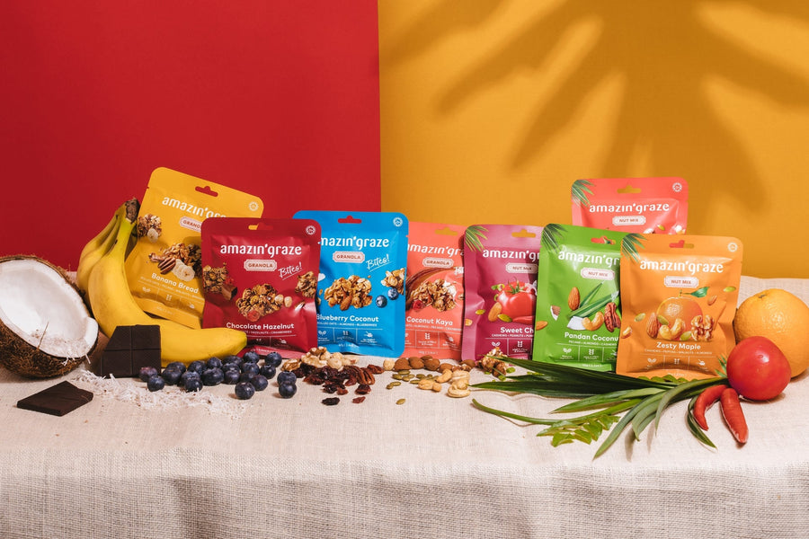 Amazin’ Graze snack packs with fruits, nuts, coconut, chocolate, and tropical ingredients.