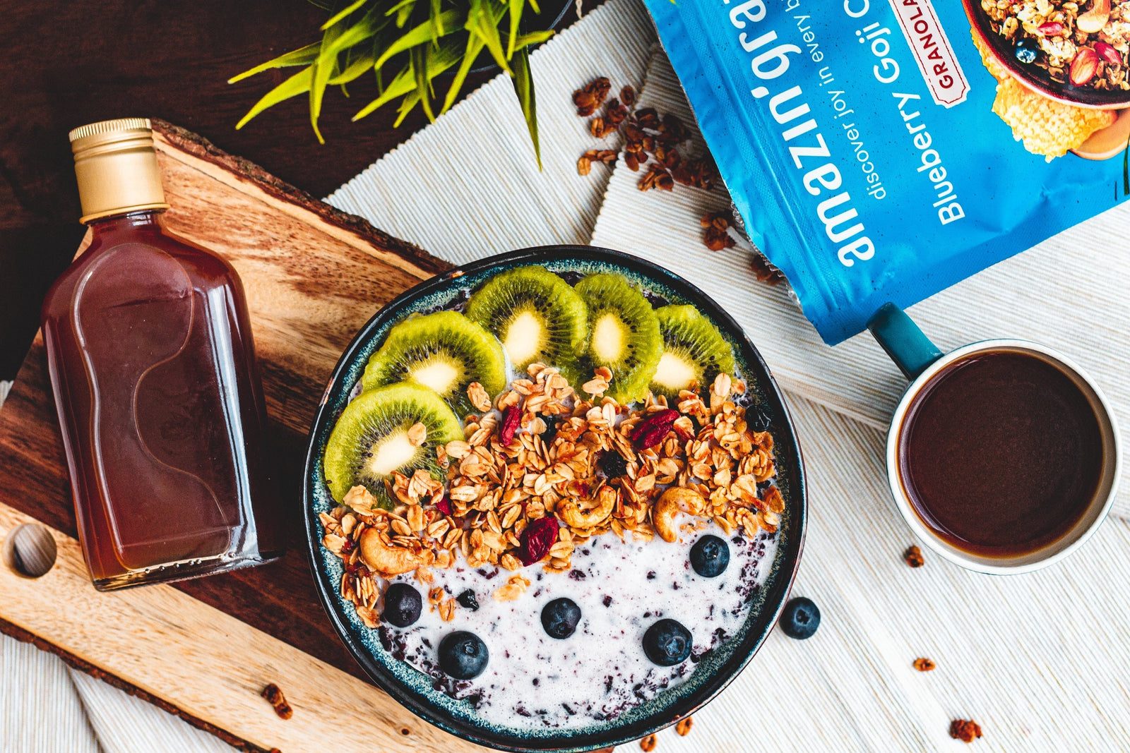 Amazin’ Graze Blueberry Goji Coconut Granola served on a smoothie bowl with kiwi, blueberries, and coffee.
