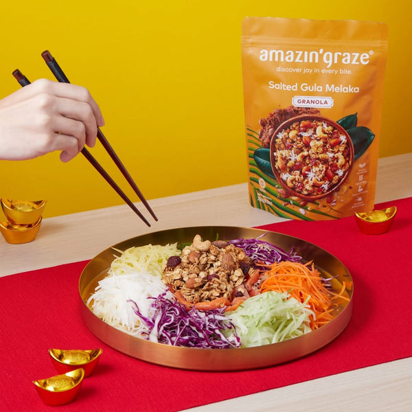 Amazin’ Graze Salted Gula Melaka Granola served with colorful festive salad and chopsticks.