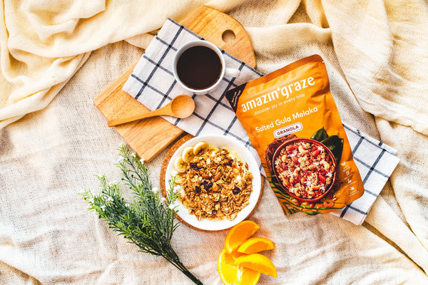 Healthy breakfast spread featuring oats, granola, nuts, seeds, and fresh fruit arranged on a bright kitchen table.
