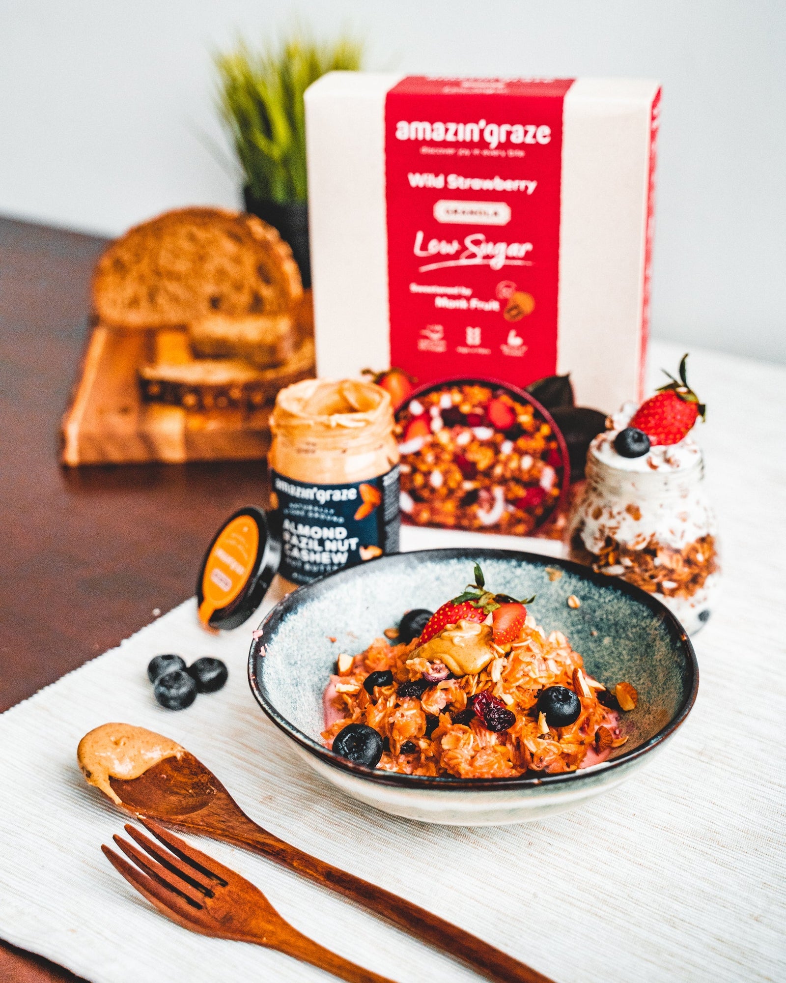 Amazin’ Graze Low Sugar Wild Strawberry Granola with almond butter, berries, toast, and breakfast bowl.